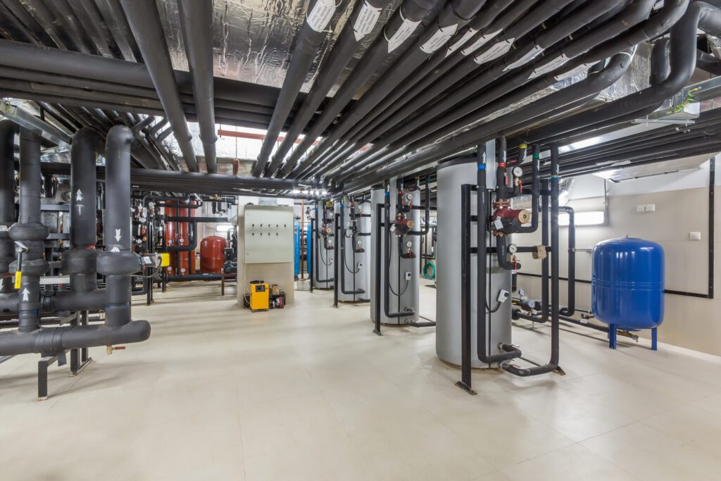 Sala de maquinaria industrial con tuberías y tanques para inspecciones OCA - RITE