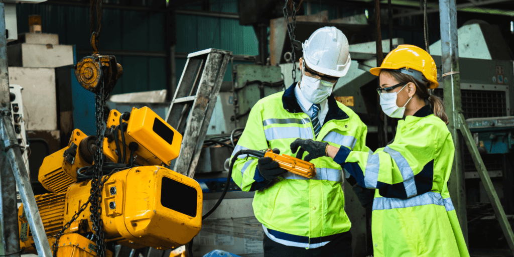 Inspectores en un entorno industrial revisando maquinaria pesada, cumpliendo con las normativas del Real Decreto 1215/1997 sobre seguridad y salud en la utilización de equipos de trabajo.